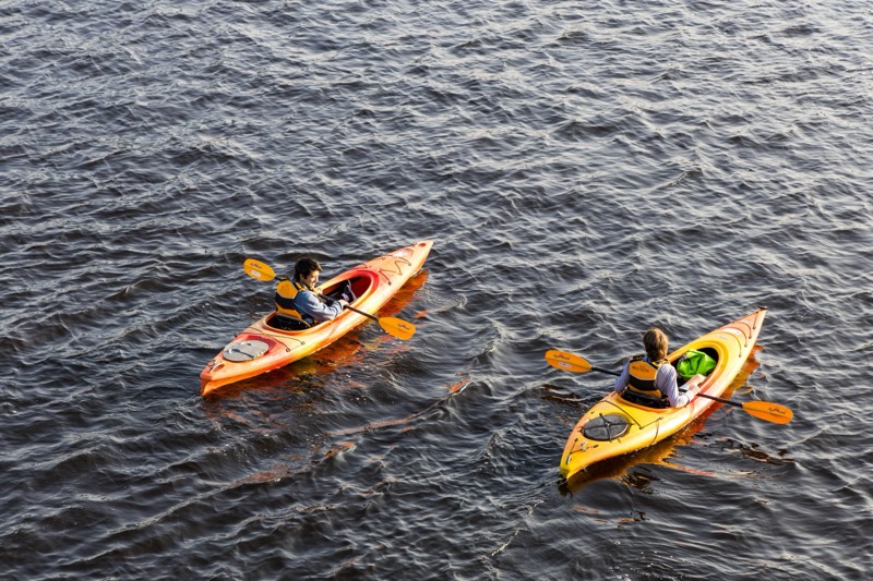 Dois praticantes de kayak a remar em águas abertas