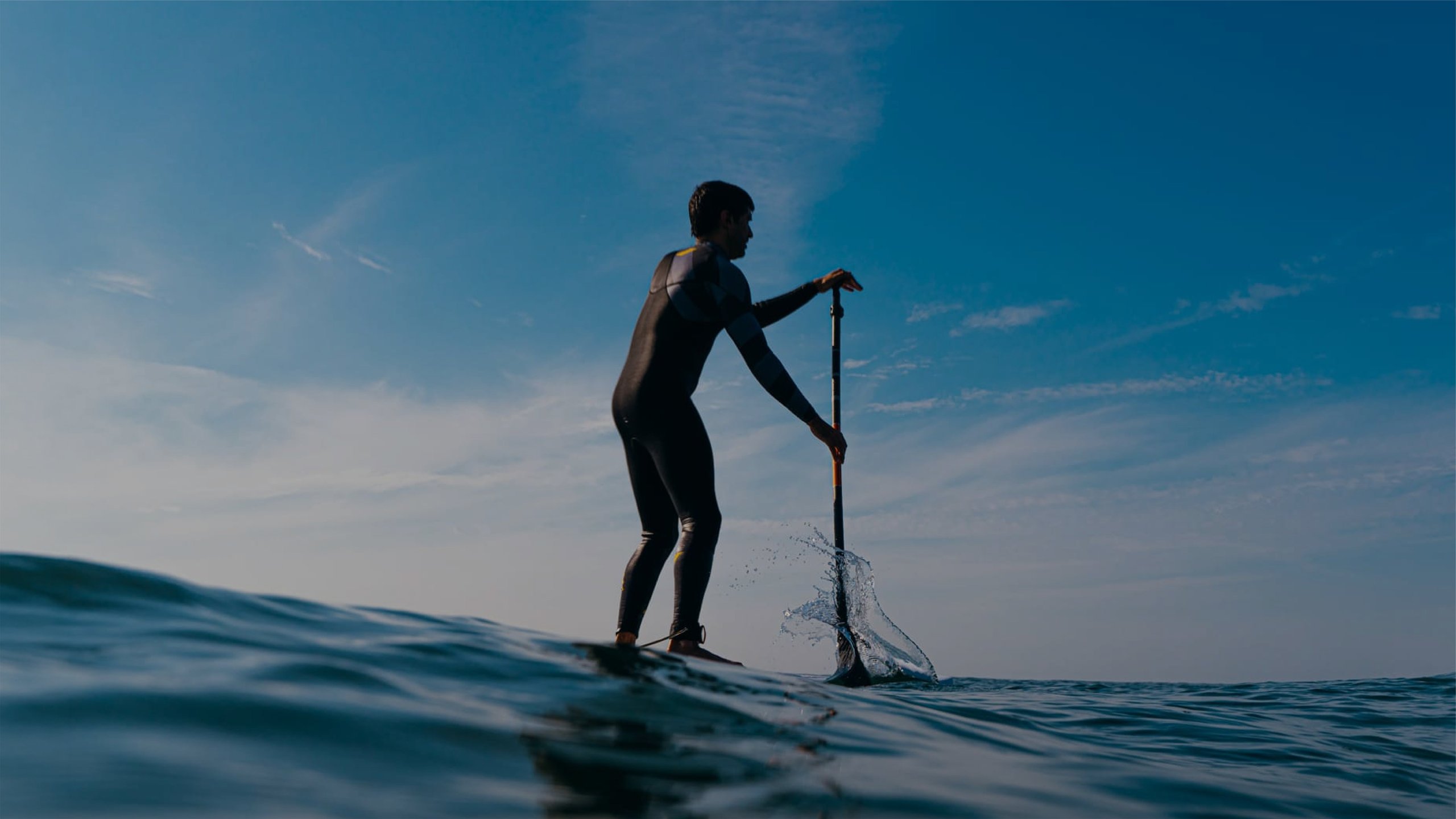 Praticante de stand-up paddle no mar